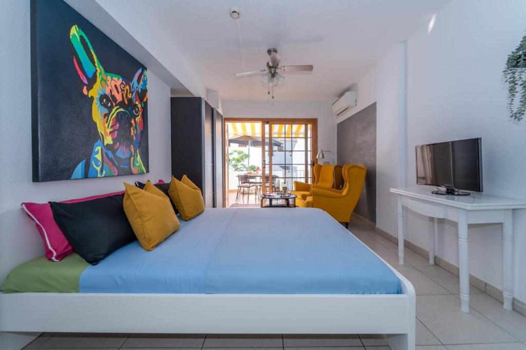 法纳贝海滩1013 studio Garden City的一间卧室配有一张带色彩缤纷枕头的大床