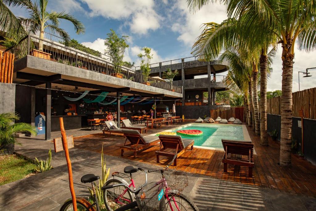 巴卡拉尔Che Bacalar Hostel & Bar Adults Only的一座带游泳池和棕榈树的房子
