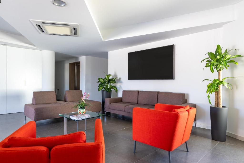 基亚拉蒙泰-古尔菲Aparthotel Grel Suite 208的客厅配有红色家具和平面电视