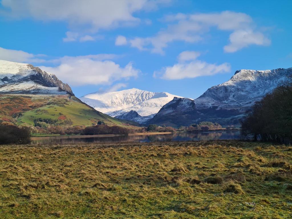 NantlleNorth Wales Cosy Cottage with views near Eryri Snowdonia的享有雪覆盖的山脉和湖泊的景致。