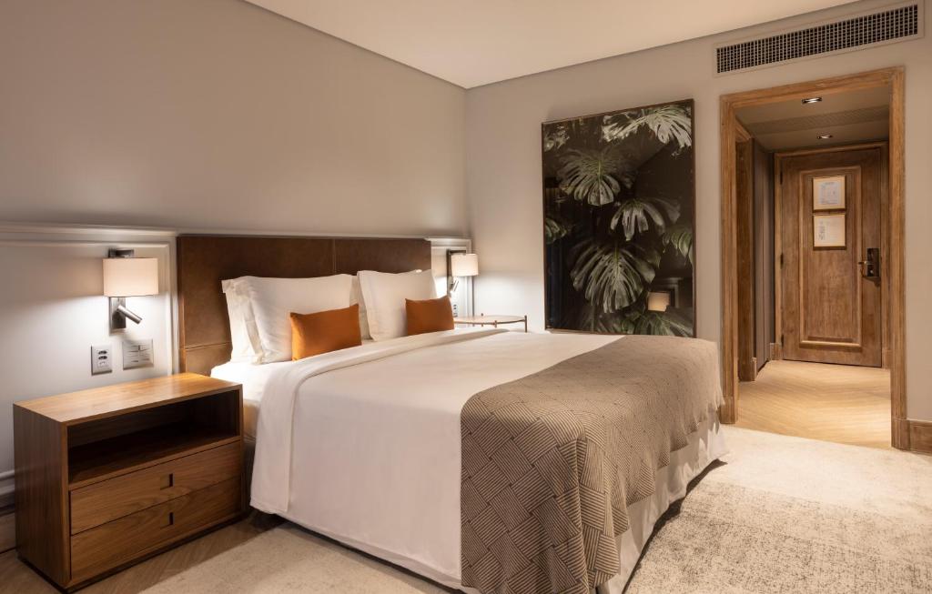 圣保罗圣保罗波尔图湾酒店的卧室配有一张白色大床和木制床头板