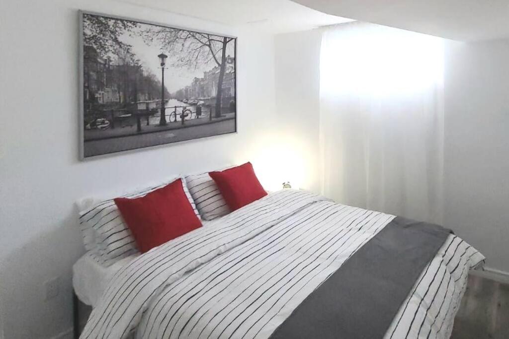 巴里Cozy 2-bedroom lower unit!的一间卧室配有一张带红色枕头的大床