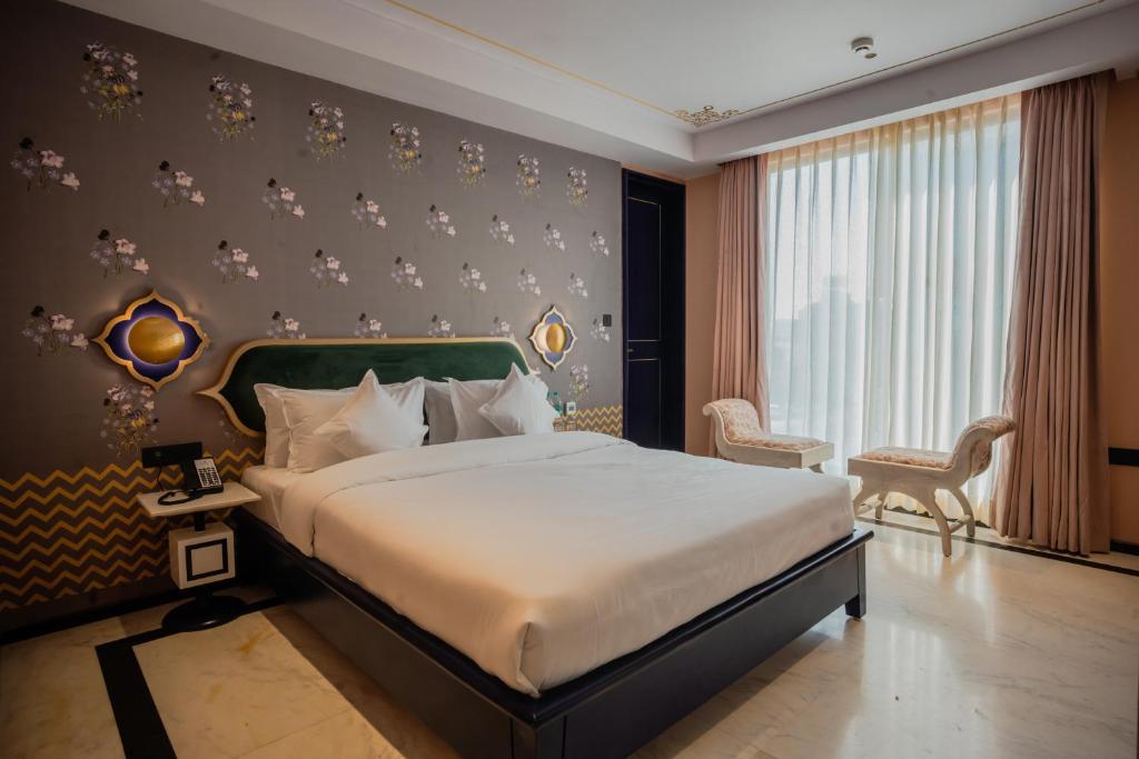 斋浦尔Bur'Dera - a Boutique Luxury Hotel的一间卧室设有一张大床和一个大窗户