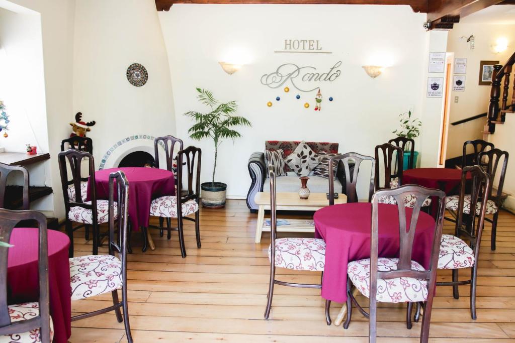 维纳德马Hotel Rondó的配有桌椅和粉红色桌布的房间