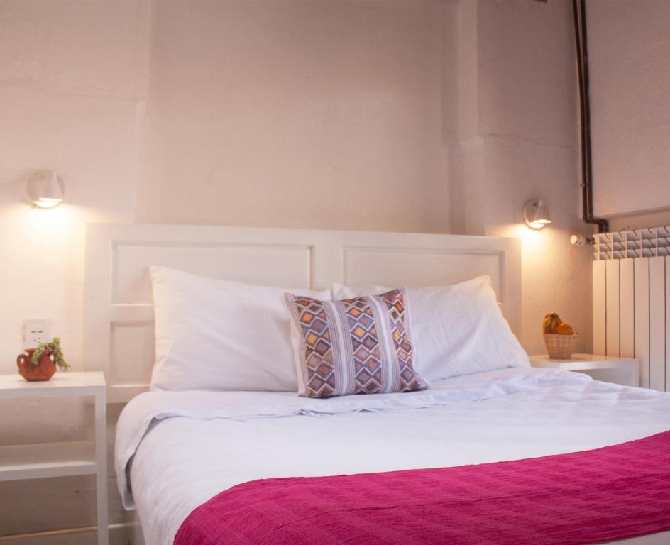 圣克里斯托瓦尔-德拉斯卡萨斯Noma Bed & Breakfast的卧室配有白色的床和2个枕头