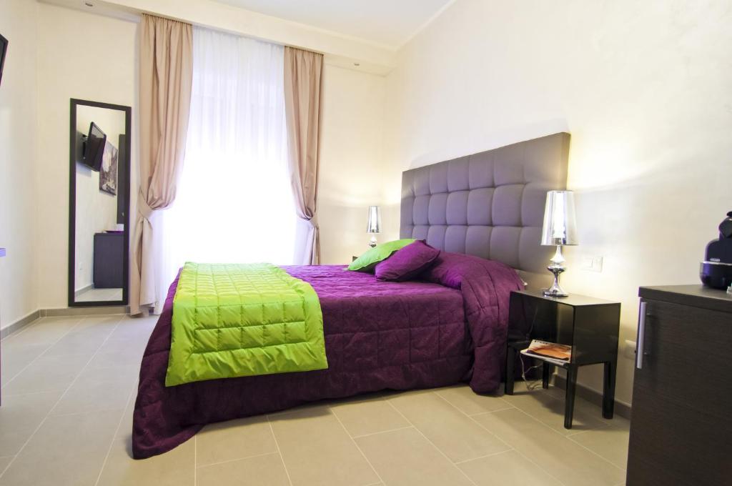 罗马多莫斯芬提斯酒店的一间卧室配有一张带绿毯的紫色床