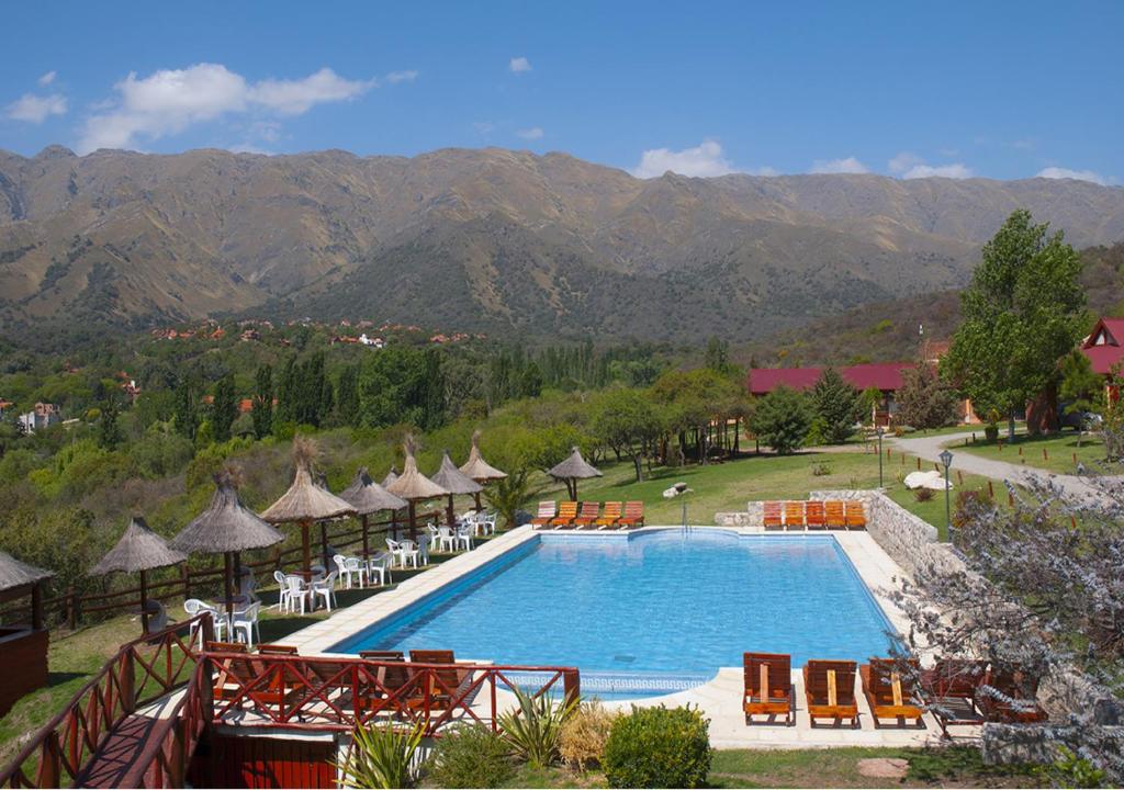 梅洛阿尔图斯德尔索尔Spa度假酒店的度假村的游泳池配有椅子和遮阳伞