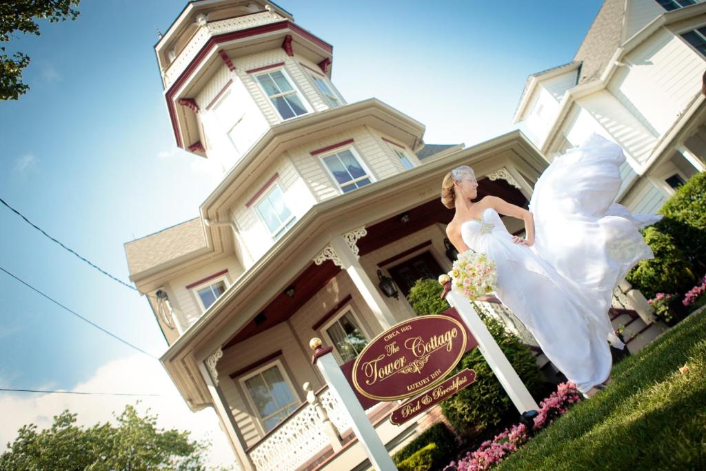 波因特普莱森特海滩塔楼小屋住宿加早餐旅馆的身着婚纱的女人在房子前