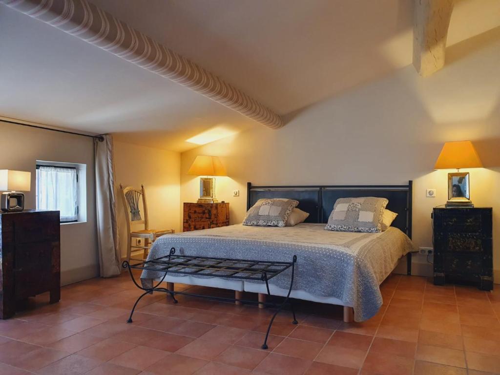 于泽斯La petite hostellerie的一间卧室配有一张大床和一张桌子