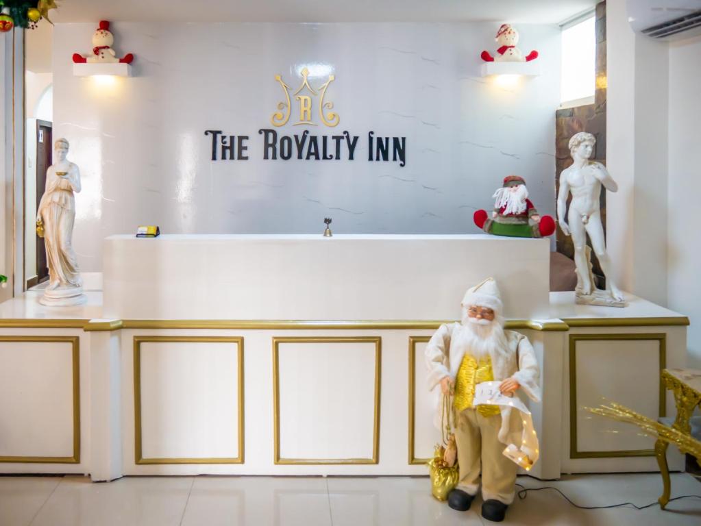 瓜亚基尔Hotel Boutique The Royalty的雕像在桌子前的桑塔条款