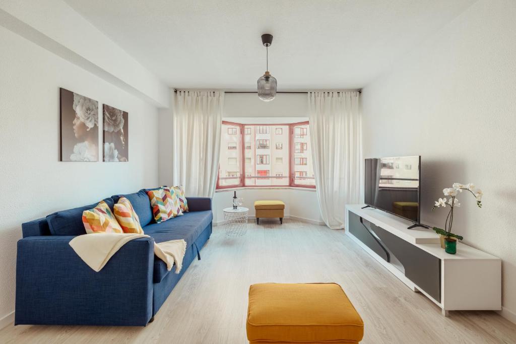 里斯本Elegant 3 bedroom apt - City centre - garage - metro的客厅配有蓝色的沙发和电视