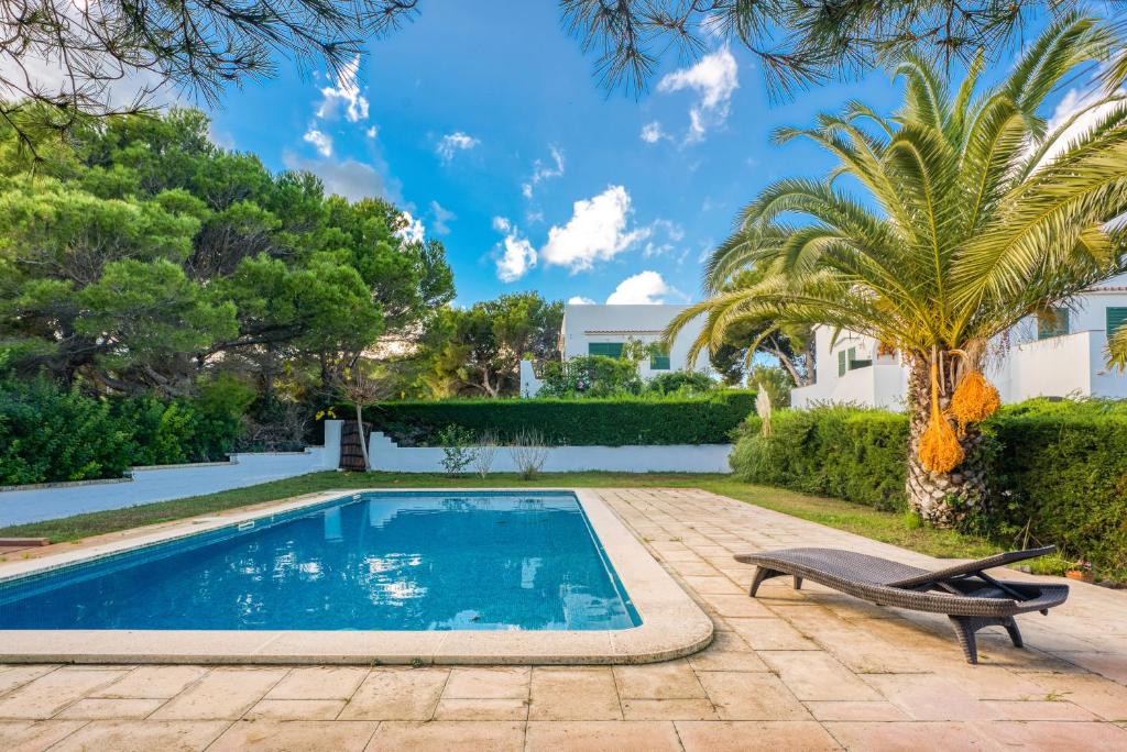 阿雷纳尔登卡斯特尔Las Violetas的一个带长凳和棕榈树的游泳池