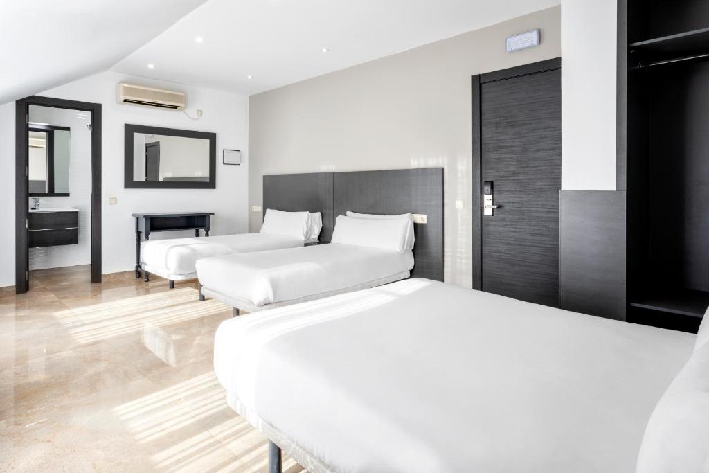 瓦尔德莫罗Hotel Victoria Valdemoro的酒店客房带两张床和一间浴室