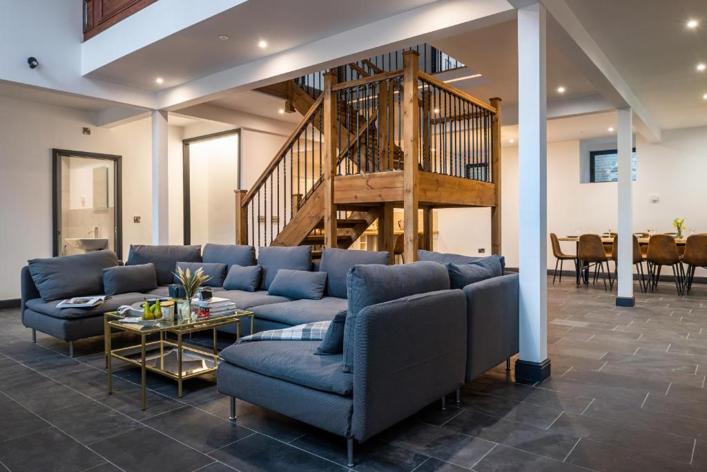 布莱奈费斯蒂尼奥格Finest Retreats - Capel Salem的客厅设有蓝色的沙发和楼梯。