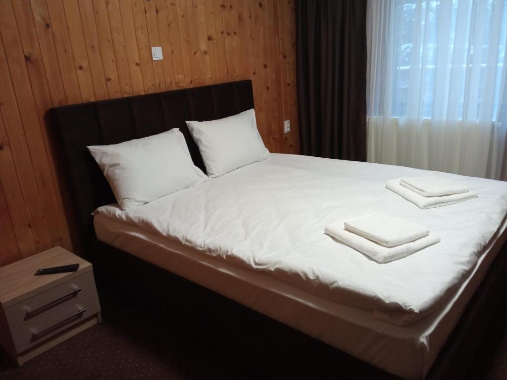 布拉索夫Casa Familiei的一间卧室配有一张床,上面有两条毛巾