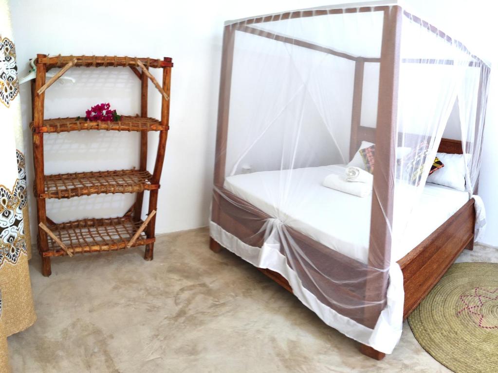 南威MaNa Nungwi的一间卧室设有一张天蓬床和书架