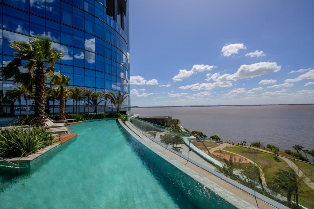 阿雷格里港DoubleTree by Hilton Porto Alegre的水面建筑前的游泳池