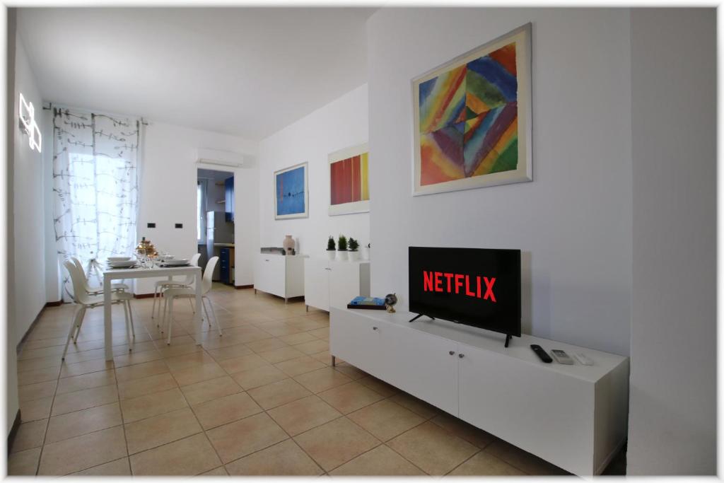 都灵[10 min metro] Palavela Suite的一间客厅,在白色的墙上配有电视