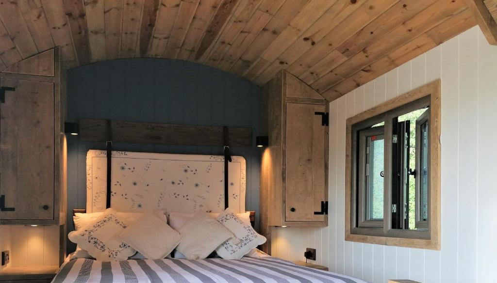 BrisleyThe Huddle at Big Sky Brisley的一间卧室设有一张带木制天花板的大床