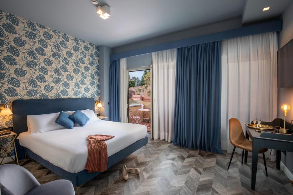 罗马Bloom Hotel Rome的配有一张床和一张书桌的酒店客房