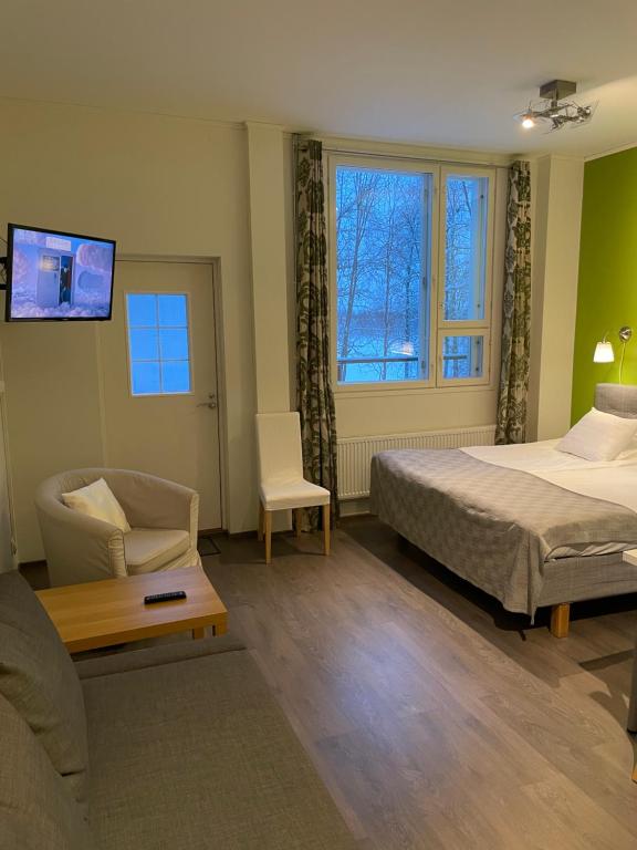 波西奥拉品萨图酒店的一间卧室配有一张床、一张沙发和一把椅子