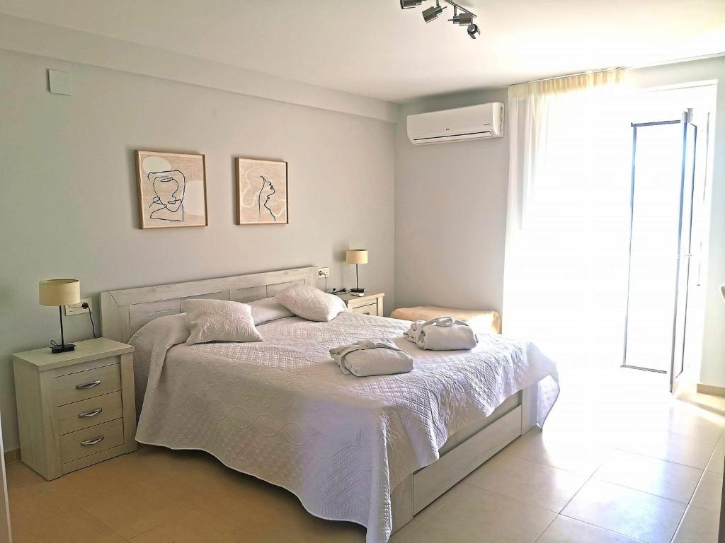 TózarMagical Andalusian Vacation "Los Arcos"的白色的卧室设有床和窗户