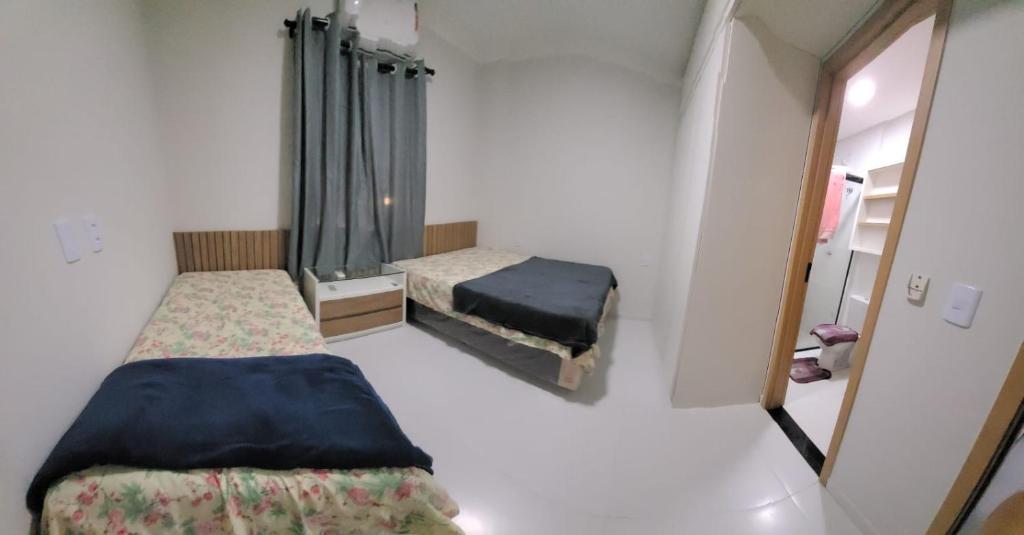 巴雷里尼亚斯Apartamento Condomínio Lençóis Confort的小房间设有两张床和镜子
