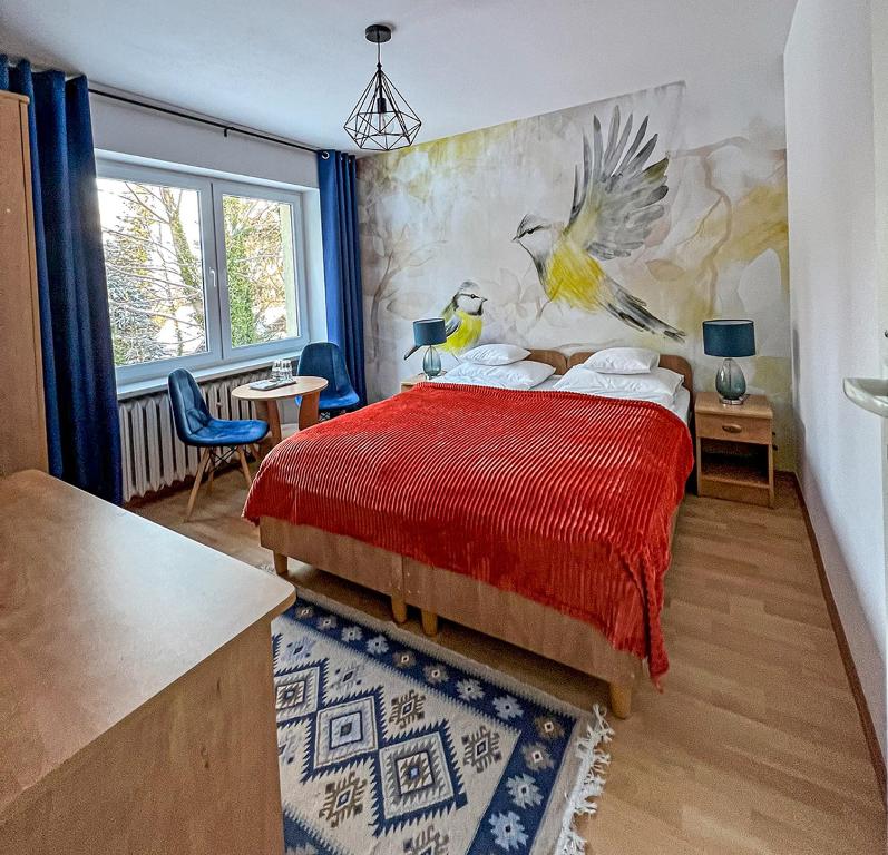 卡尔帕奇Willa RADosna的卧室配有红色的床,墙上挂有绘画作品