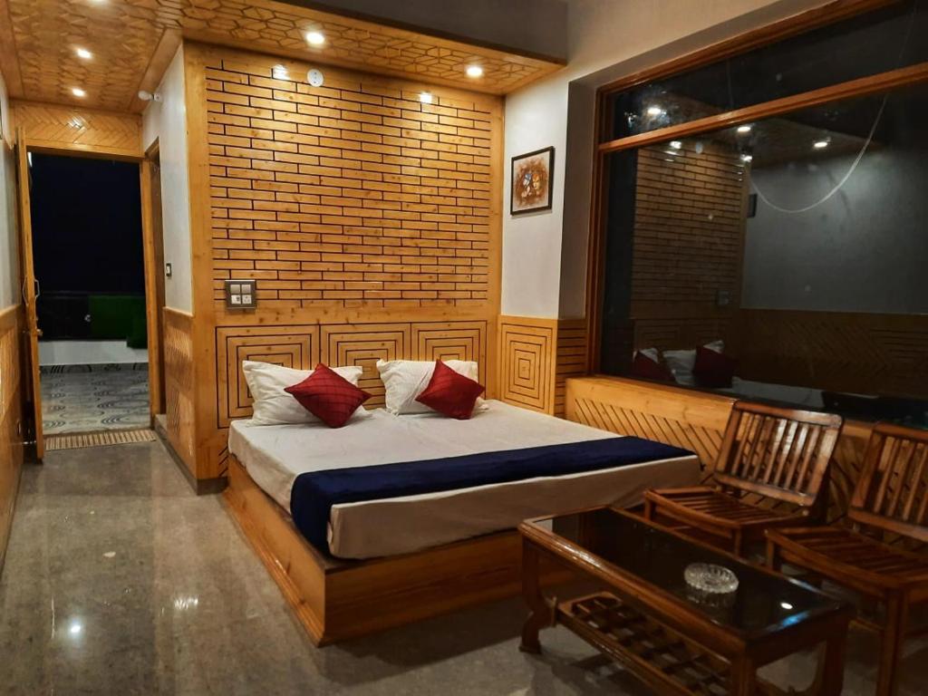 西姆拉The MoonLight Stay - Shimla的卧室配有床、椅子和窗户。