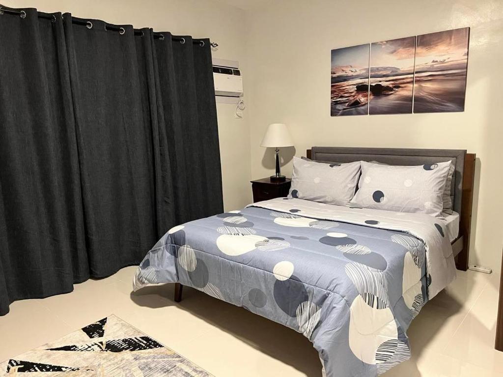 巴科洛德7F Majorca, Camella Manors Bacolod Condo的一间卧室配有一张带蓝色棉被的床