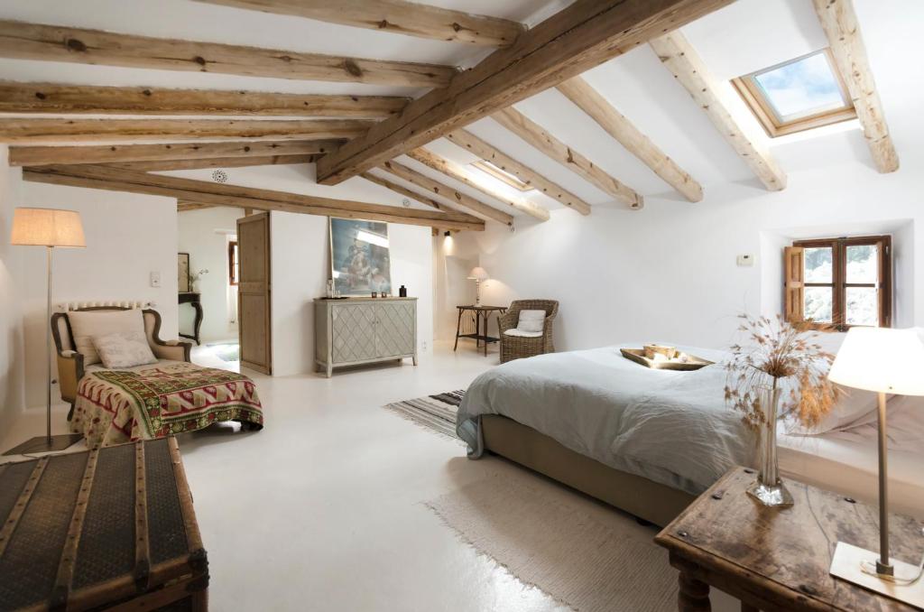 巴尔德莫萨索恩维斯克斯农场酒店的卧室拥有白色的墙壁和木制天花板。