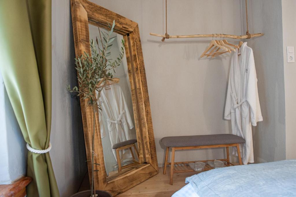 约阿尼纳locanta的一间卧室配有镜子、椅子和一张床
