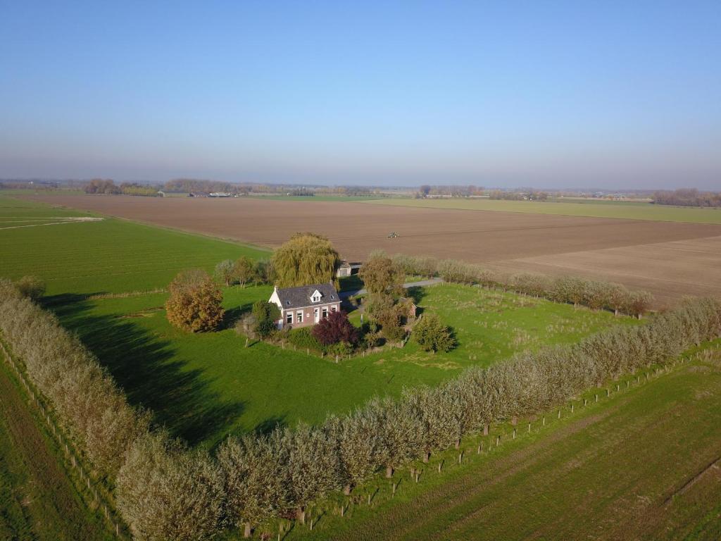 AxelLandhuis 'De Ontspanning'的绿色田野上房屋的空中景观