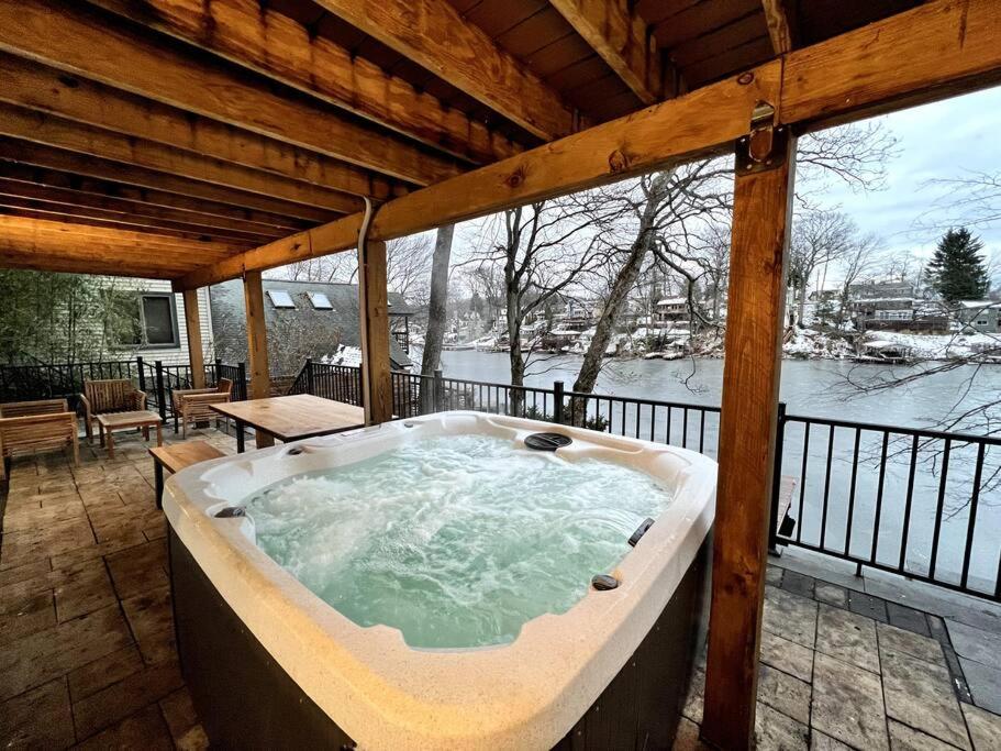 HopatcongCozy Cabin on the Lake w/ HotTub的门廊上的按摩浴缸,享有雪景