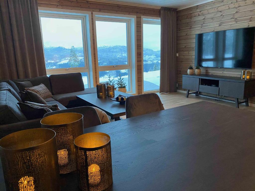 斯屈勒斯塔穆New modern apartment with great view - ski in & out的客厅配有桌椅和电视