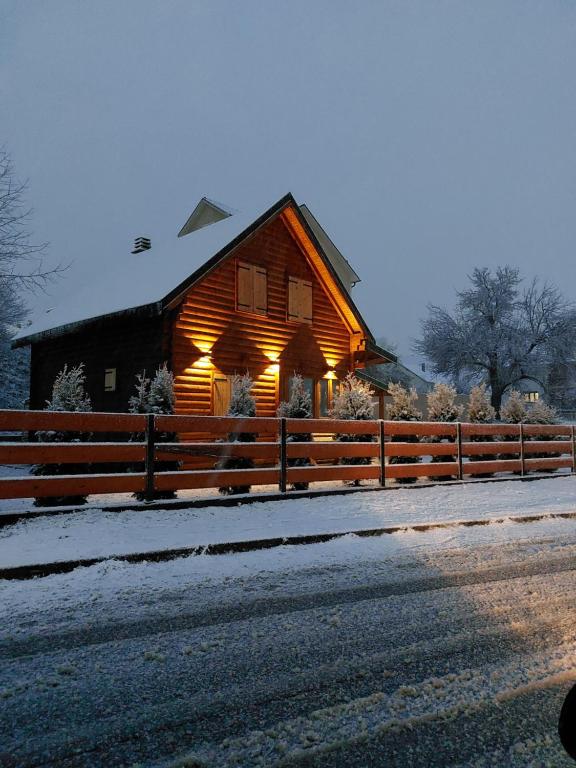 科拉欣Zara Chalet的雪中带灯的木制谷仓