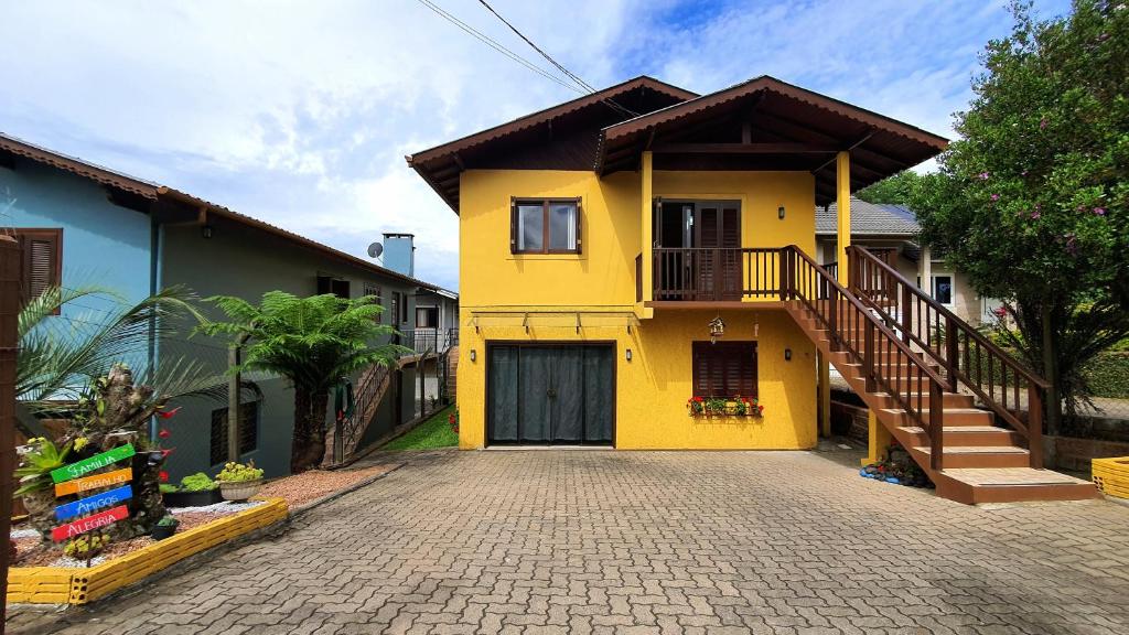 卡内拉Casa Palace Canela的车道上设有楼梯的黄色房子