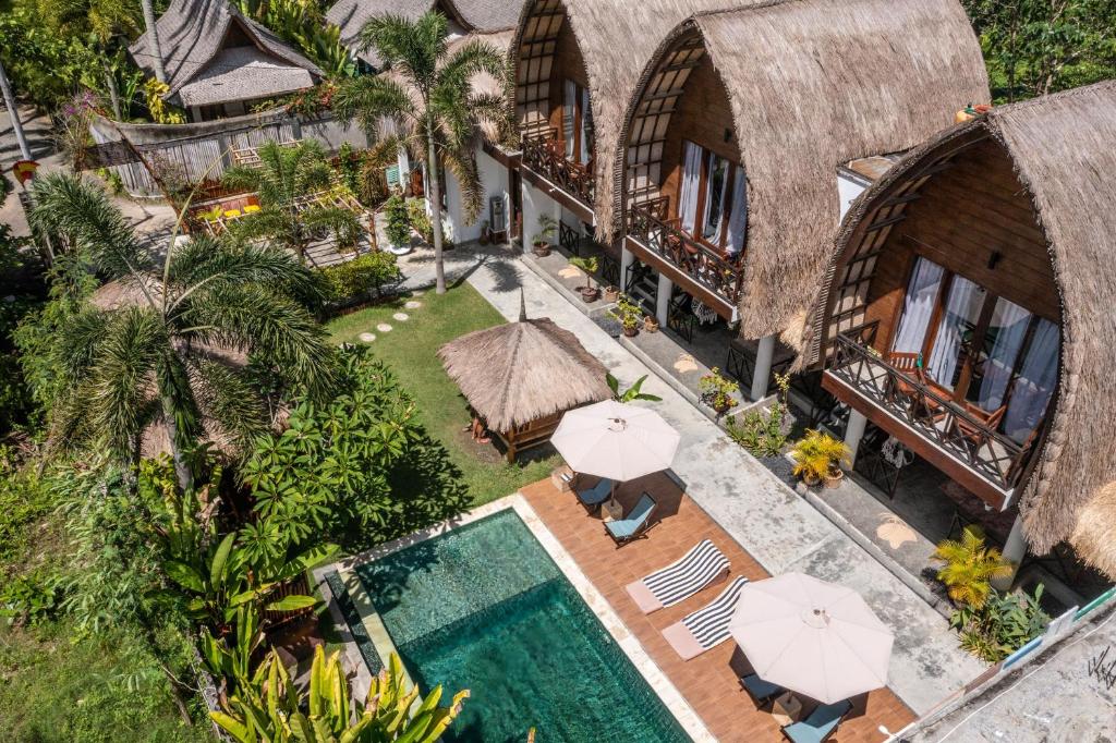 龙目岛库塔马尔塔斯温多斯酒店的享有度假村的空中景致,设有游泳池和遮阳伞