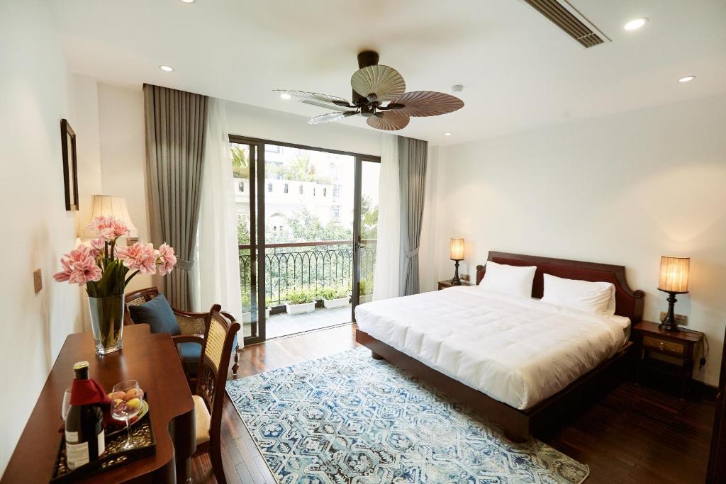 河内Camellia Residence Hanoi的一间卧室配有一张床、一张桌子和一张四柱床。
