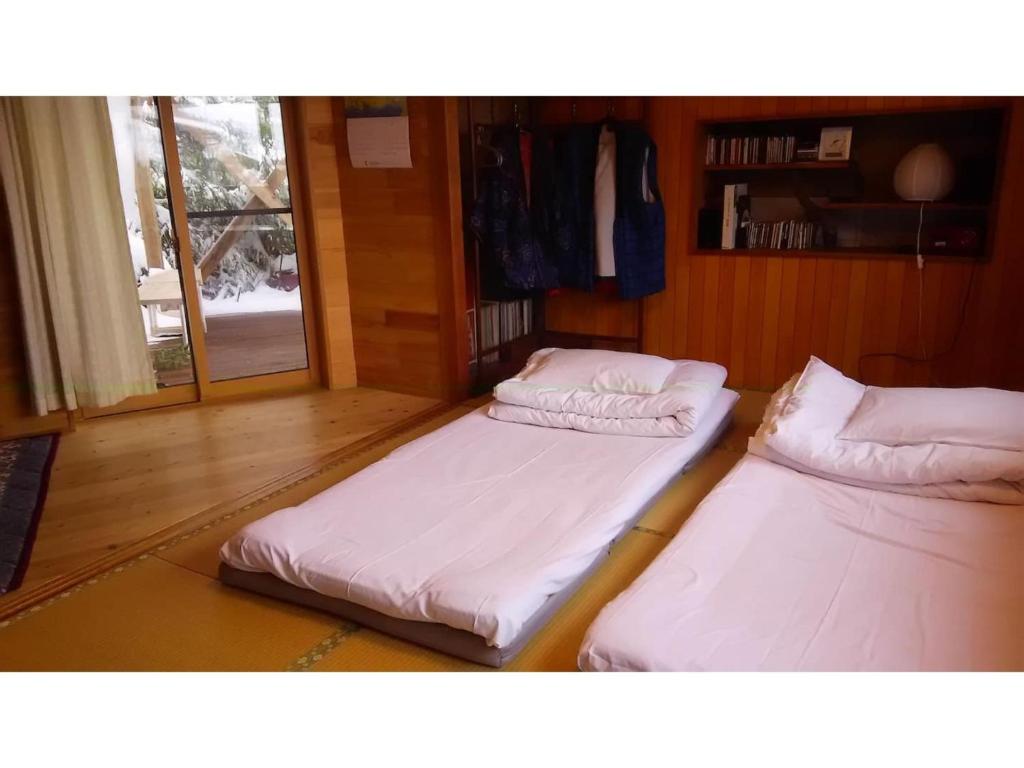 高山Tomareru sento taka no yu - Vacation STAY 00567v的带窗户的客房内设有两张单人床。