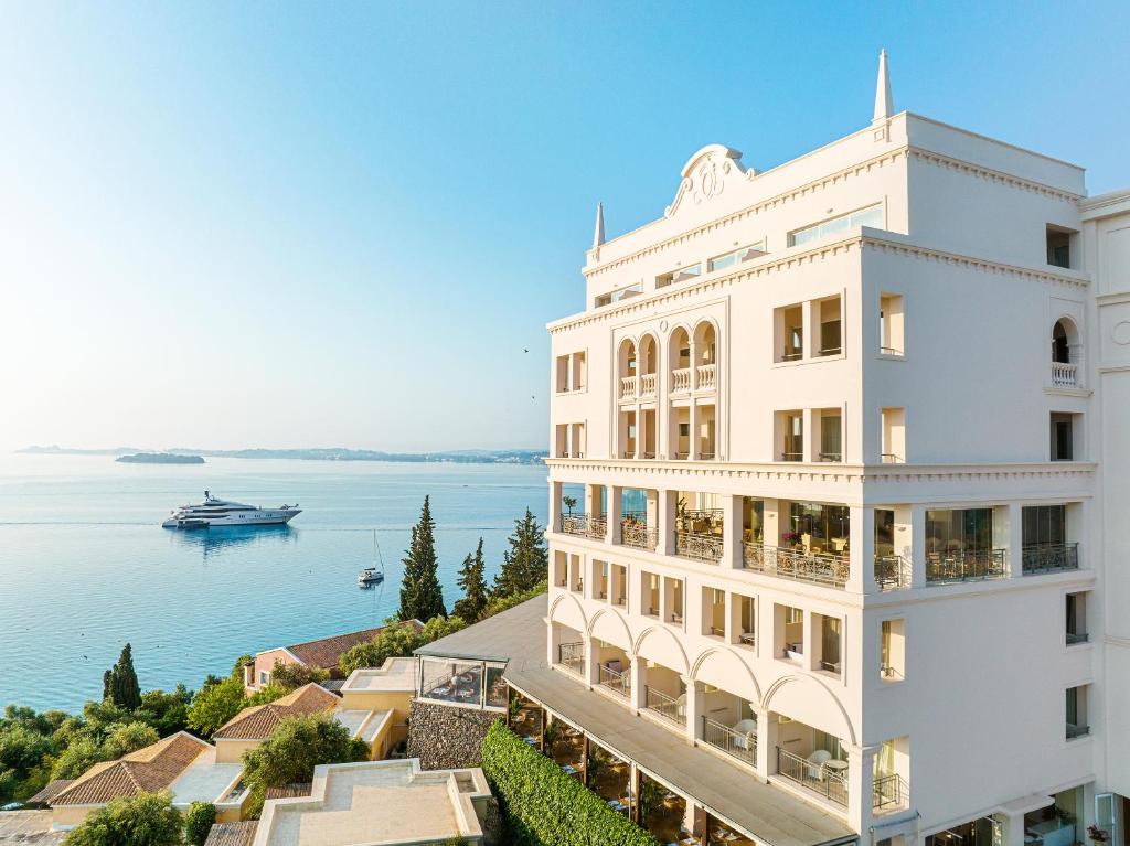 科梅诺格雷科泰尔伊宫酒店的白色的建筑,俯瞰水面,有船