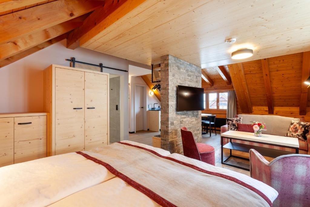 安德马特Sonne Andermatt Swiss Quality Hotel的一间带一张大床的卧室,位于一个拥有木制天花板的房间