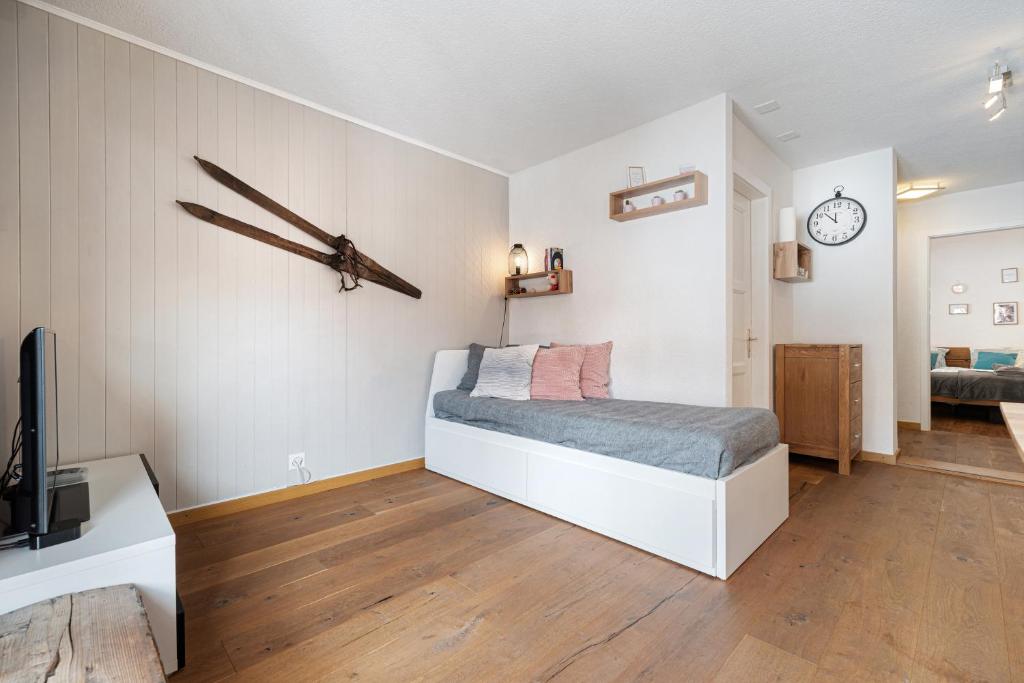 奥瓦伦纳茨Appartement chaleureux à Ovronnaz的卧室配有一张床,墙上挂着一个钟