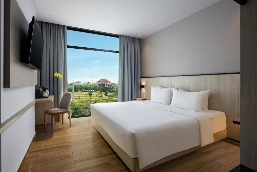 巴淡岛中心Hotel Santika Batam的卧室设有白色的床和大窗户