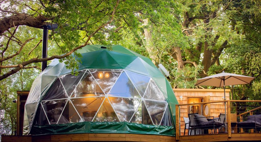 ChiddingstoneLuna Domes的甲板上配有椅子和遮阳伞的帐篷