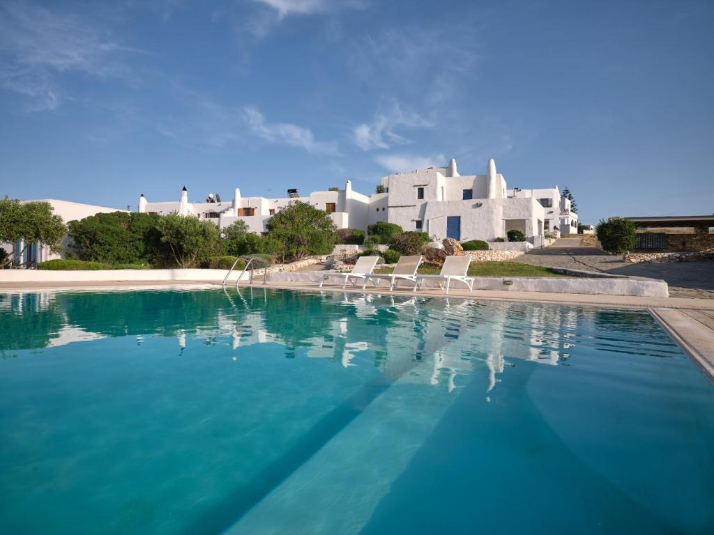 帕罗斯岛Nola Traditional Villa with pool and amazing sea views, Paros的一座白色大建筑前的游泳池