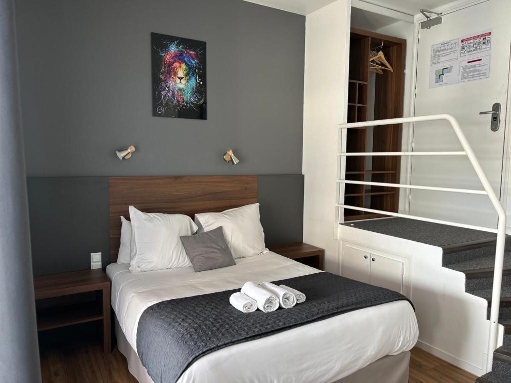 维希现代酒店的一间卧室配有一张床,上面有两条毛巾