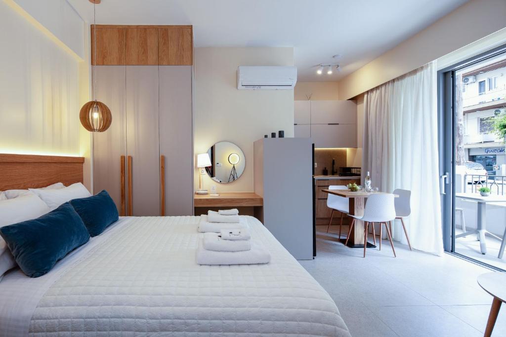 罗希姆诺7 City Luxury Apartments的一间带白色大床的卧室和一间厨房