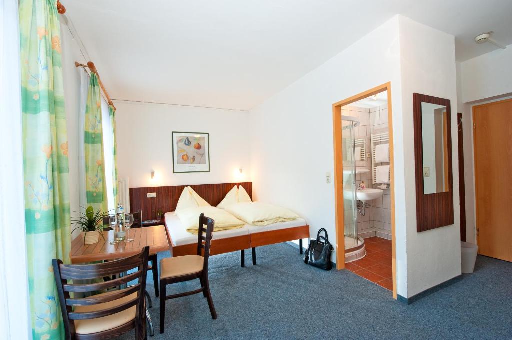 巴特霍夫加施泰因帕尔克加施泰因酒店的一间卧室配有一张床、一张桌子和一张桌子