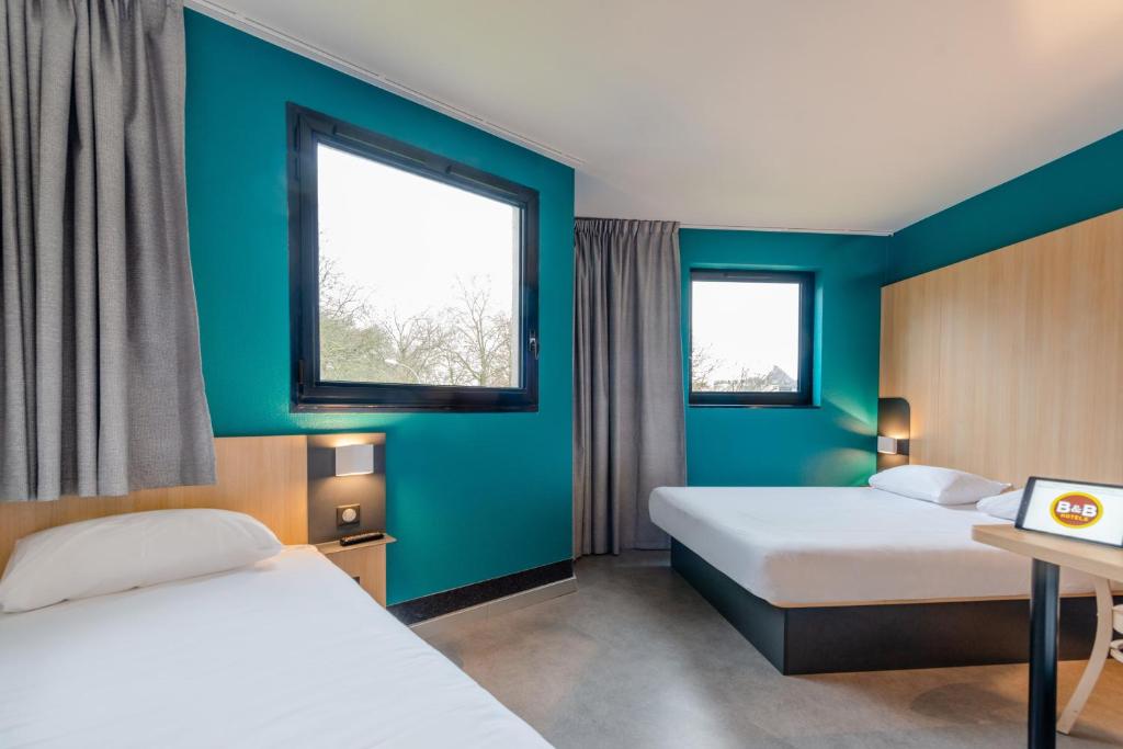 绍莱B&B HOTEL Cholet Sud的酒店客房带两张床和两个窗户